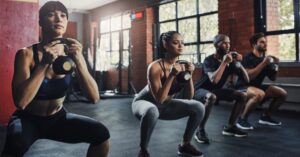 People doing kettlebell squats in group fitness classes in New York City